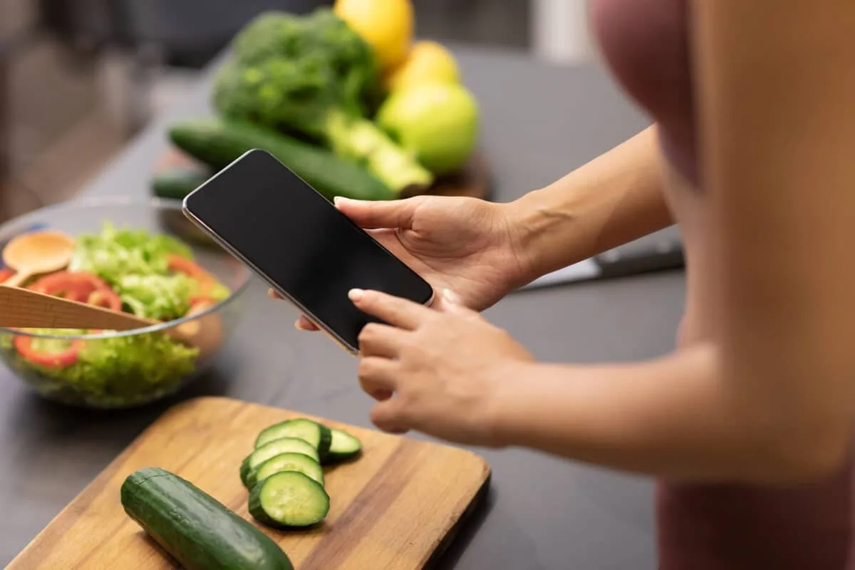 Femme utilisant son téléphone pour chercher des recettes saines