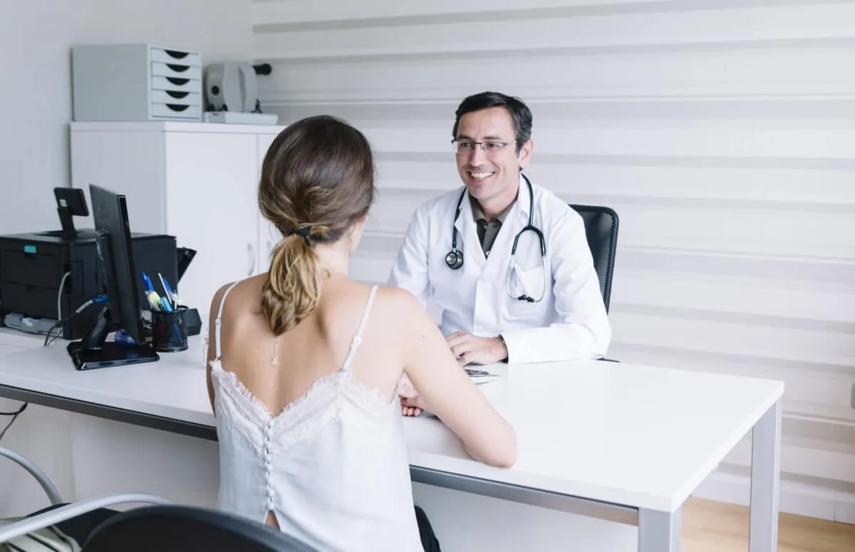 Médecin homme consultant une patiente dans un cadre inclusif et diversifié